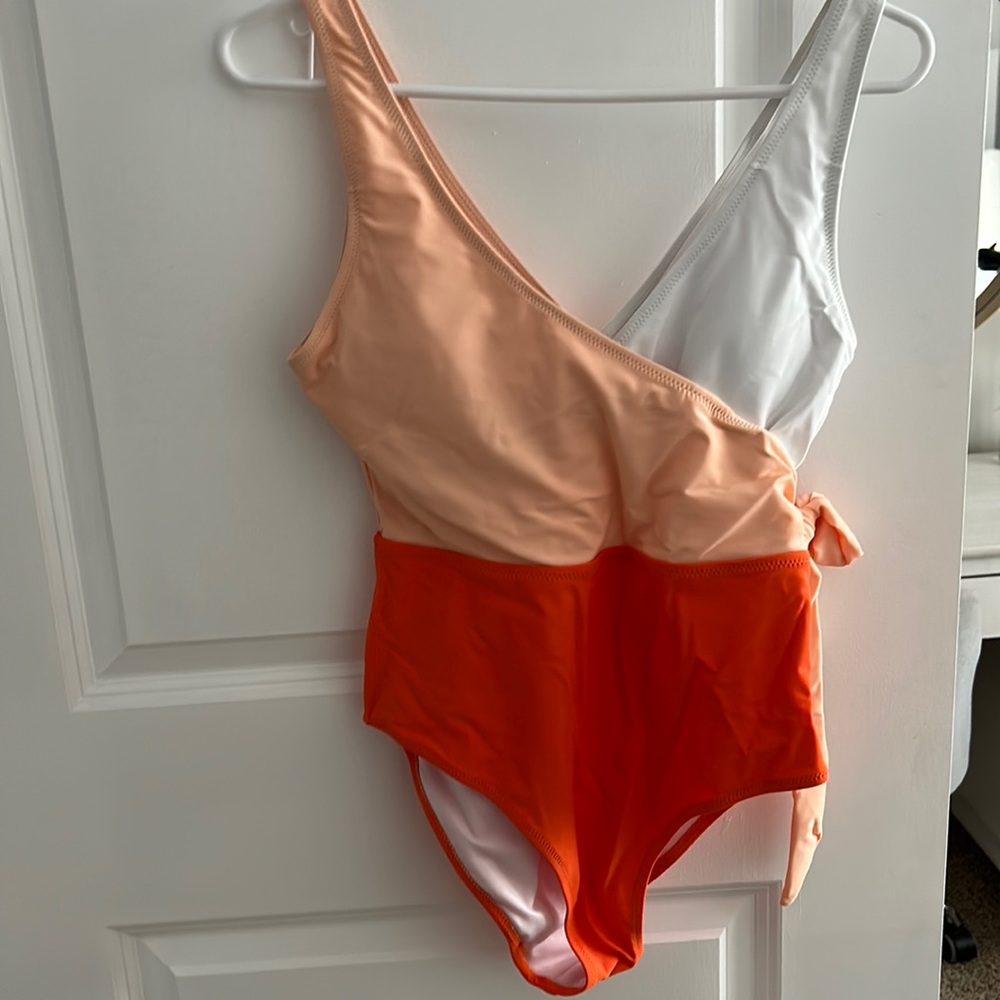 one piece swimsuit, pads included, cute little tie on the side, v cut